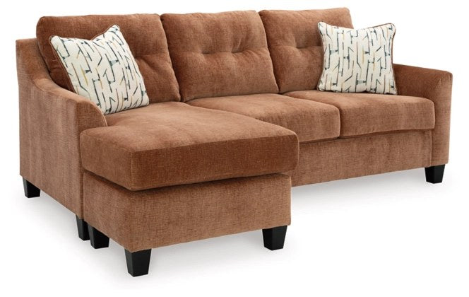 Ashley Amity Bay Tufted Fabric Club Chair, Blue and Brown - Full front view of the Ashley sectional sofa with a left-arm facing chaise, upholstered in a warm brown textured fabric, highlighting the same design details and accent pillows.