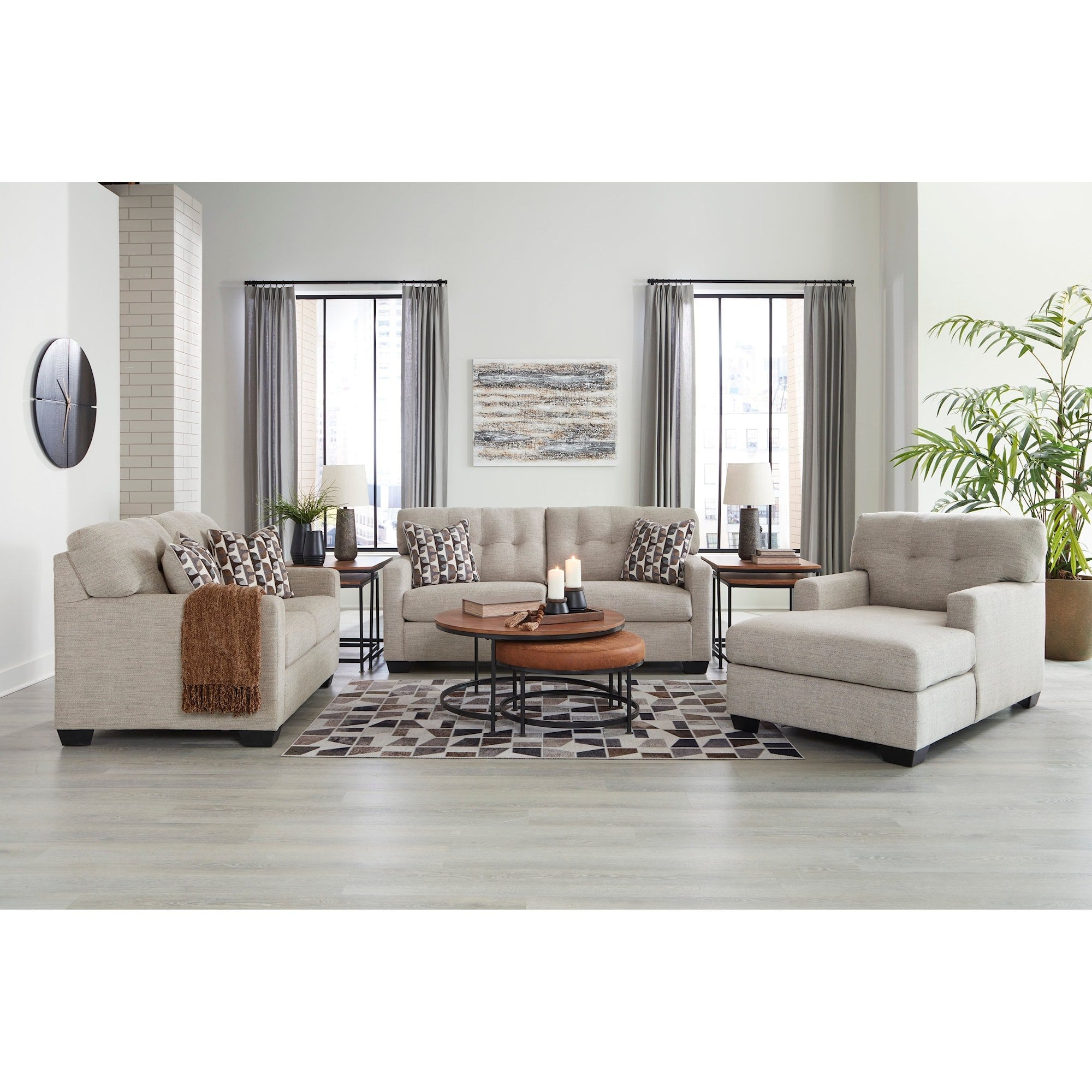Full living room scene showcasing the Ashley sofa, loveseat, and chaise lounge, highlighting the collection's contemporary style and light gray upholstery in a bright setting.