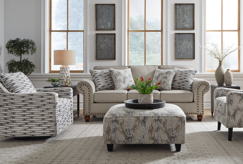 Full living room scene showcasing the transitional sofa, coordinating swivel chair, and ottoman in a well-decorated setting.