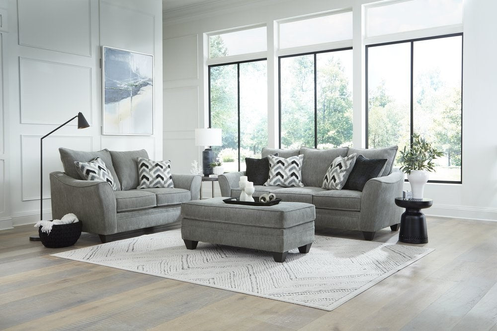 The complete Haze Gray collection in a bright, modern living room, showcasing the sofa, loveseat, and ottoman, setting the style for the club chair.